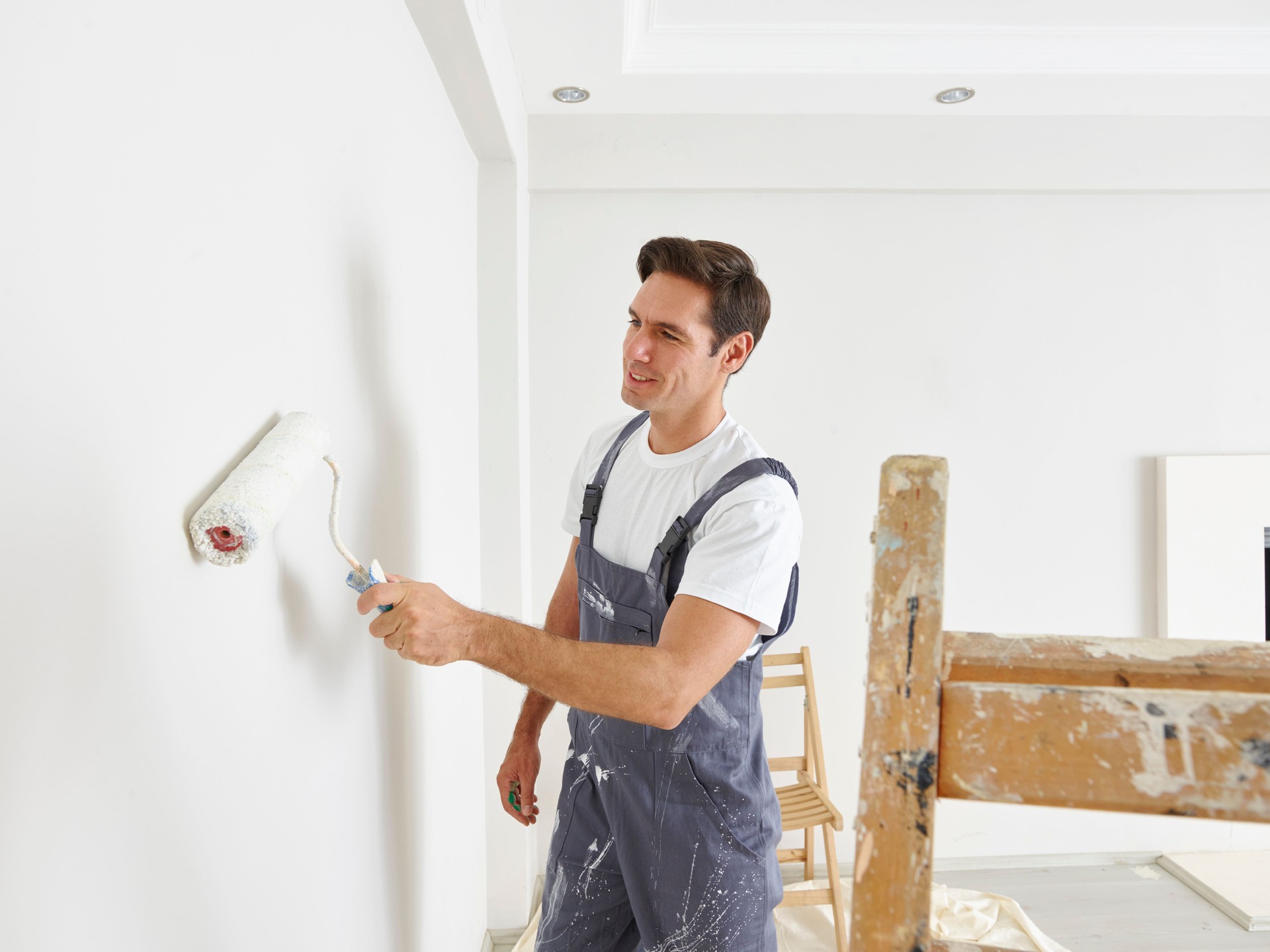 Man painting wall with a roller